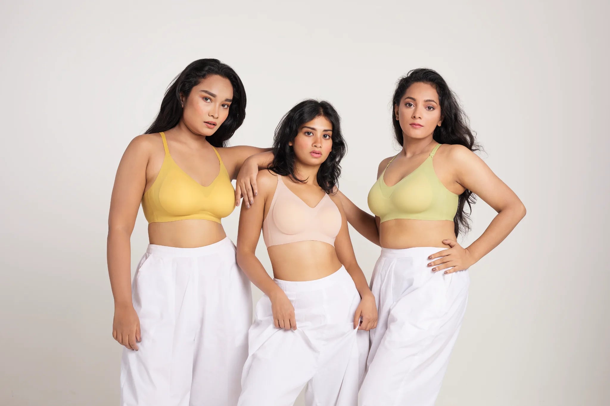 Three models wearing yellow, nude and lime green SHAPE Seamless Lite Bras