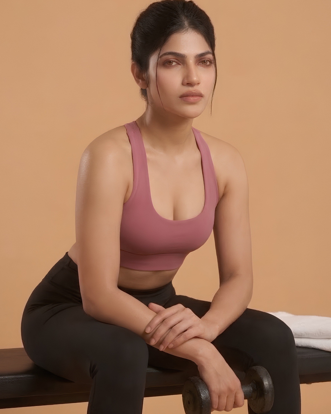 Power Sculpt Sports Bra in Pink, worn by a woman seated with a dumbbell, SHAPE Lingerie